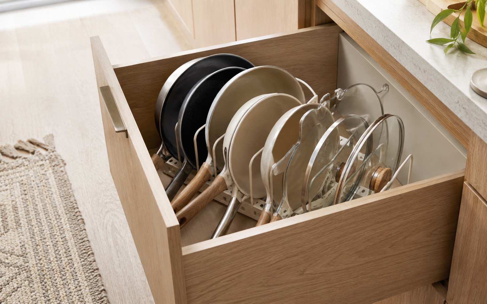 Cajón de cocina con tapas y sartenes ordenadas